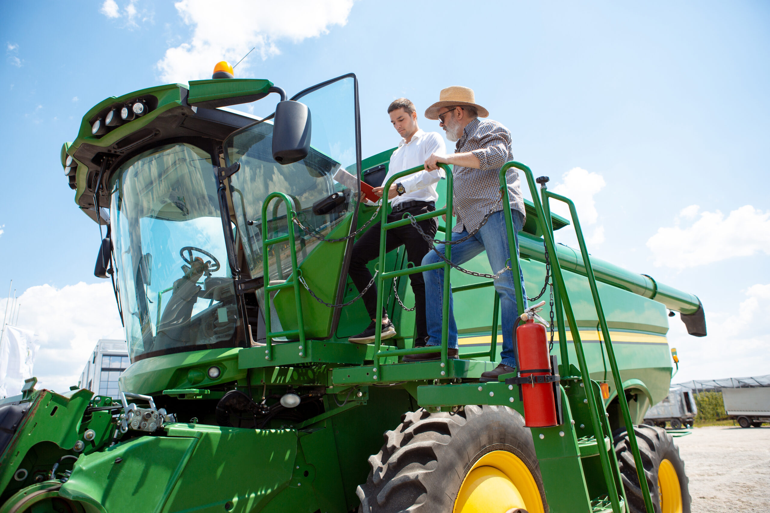 A farmer with a tractor, combine at a field in sunlight. Confident, bright colors